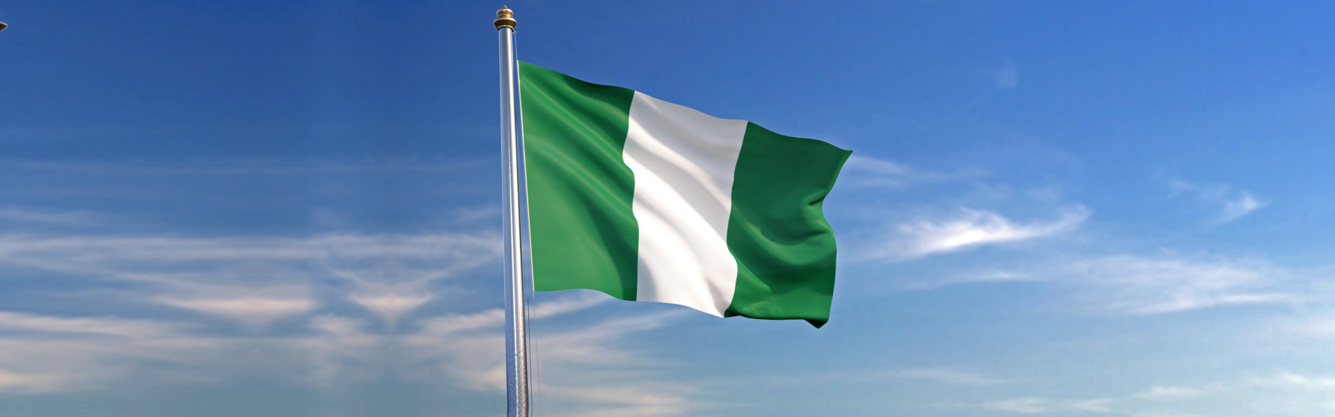 Flag of Nigeria rise waving to the wind with sky in the background